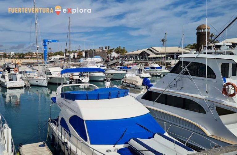 Embarcaciones y centro de ocio al fondo en Puerto Deportivo Castillo