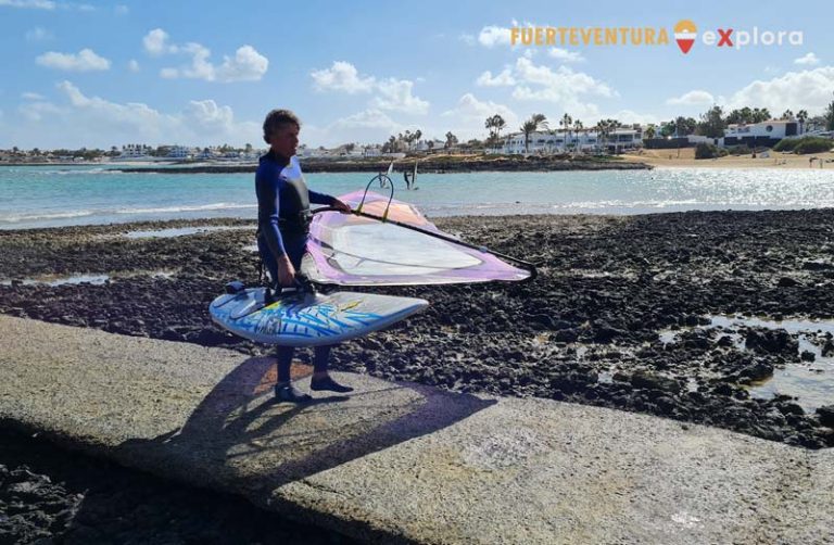 Windsurfer che esce dall'acqua nella spiaggia di Corralejo